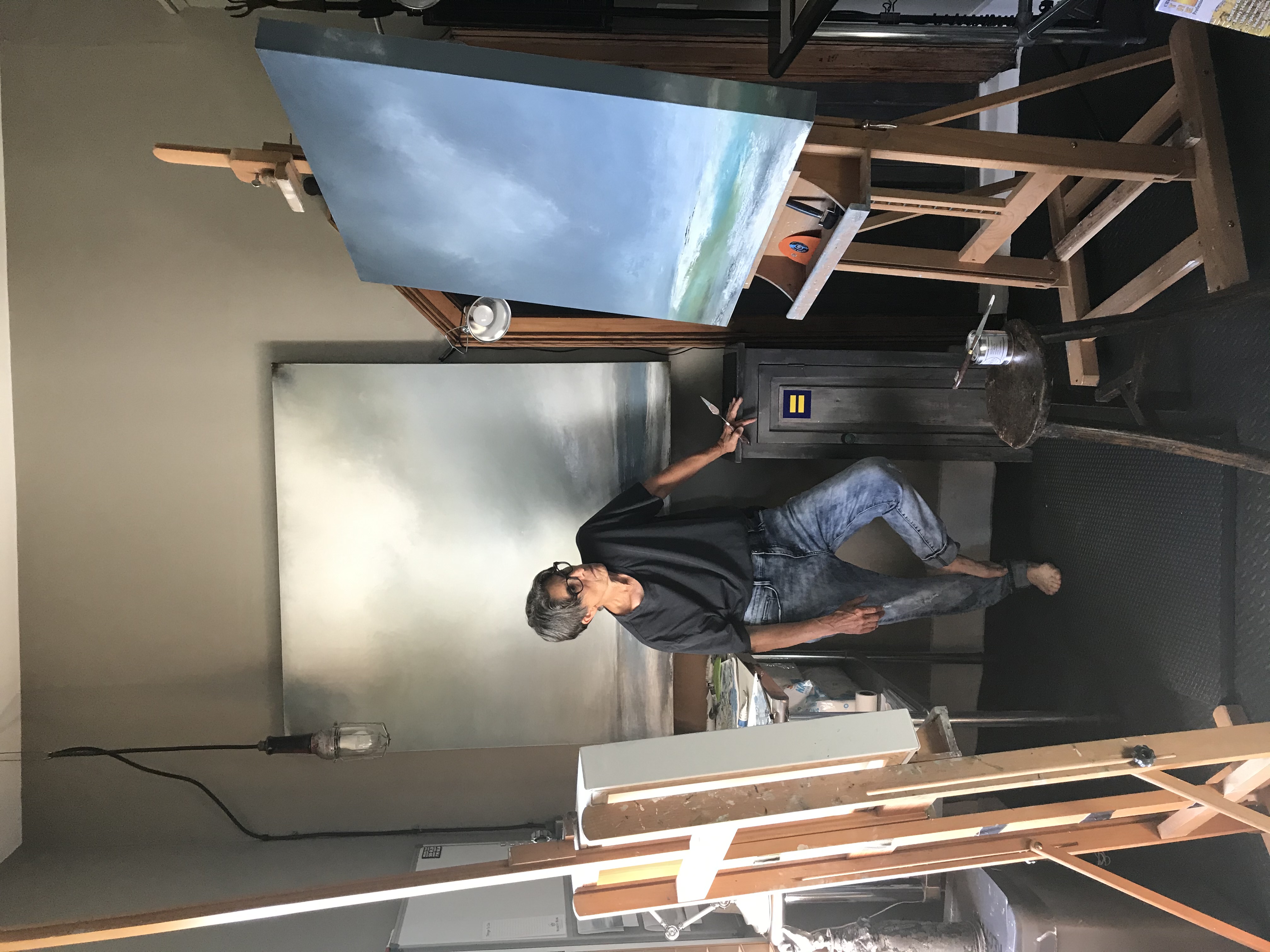 A Person Standing Next To A Painting Easel